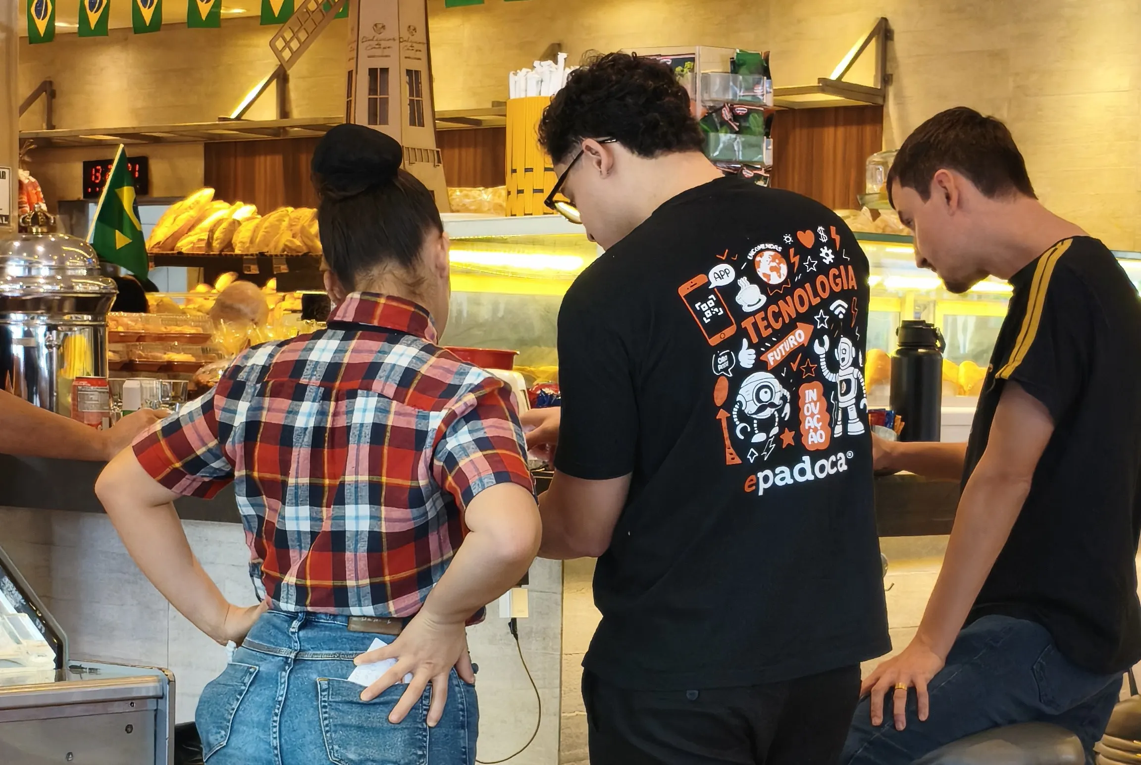 Equipe da Epadoca conversando com uma atendente no balcão de uma padaria