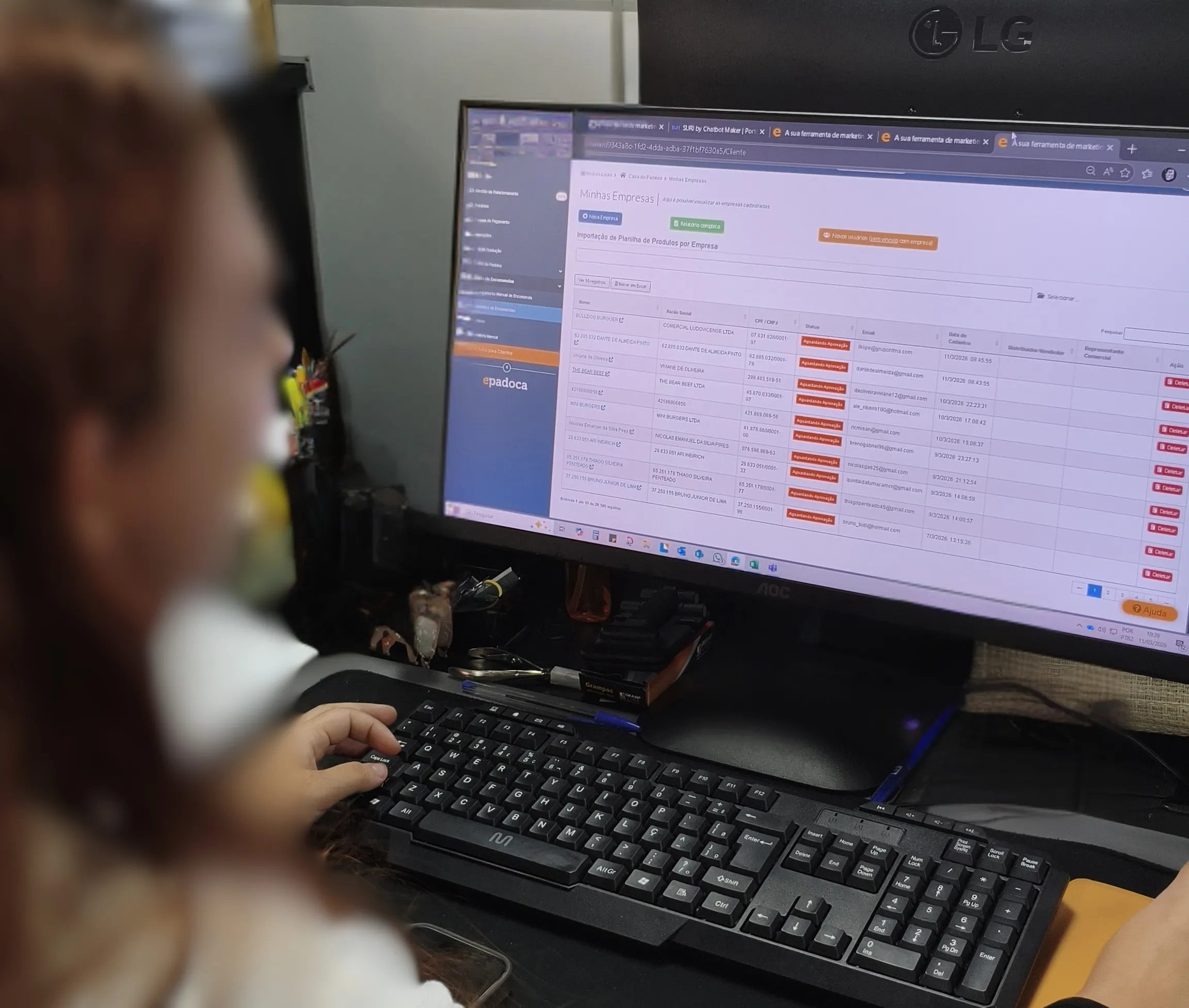 Funcionária consultando uma lista de pedidos no computador